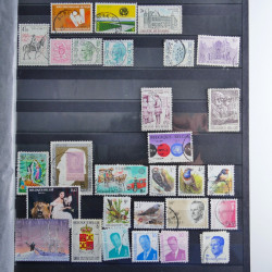 Vrac philatélique de timbres du monde neufs et oblitérés en un carton.