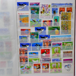 Vrac philatélique de timbres du monde neufs et oblitérés en un carton.